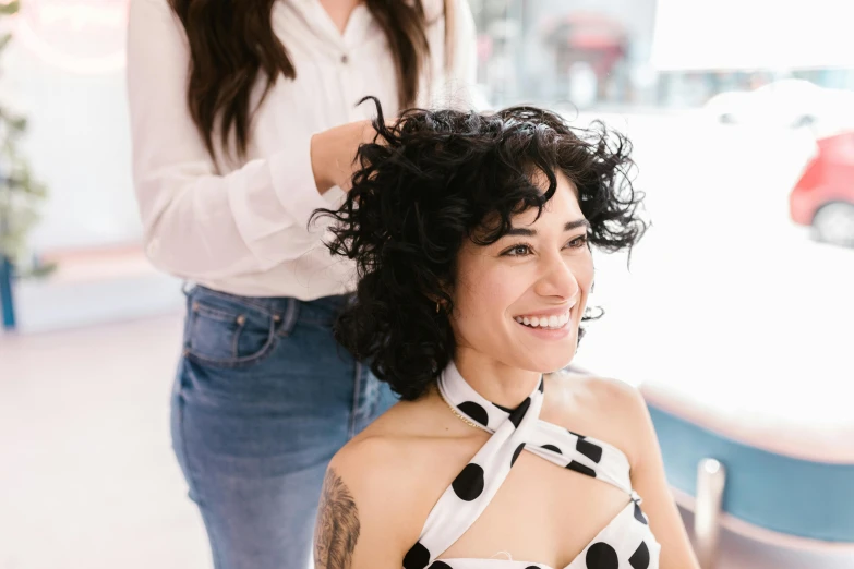 a woman is sitting in the chair being trimmed