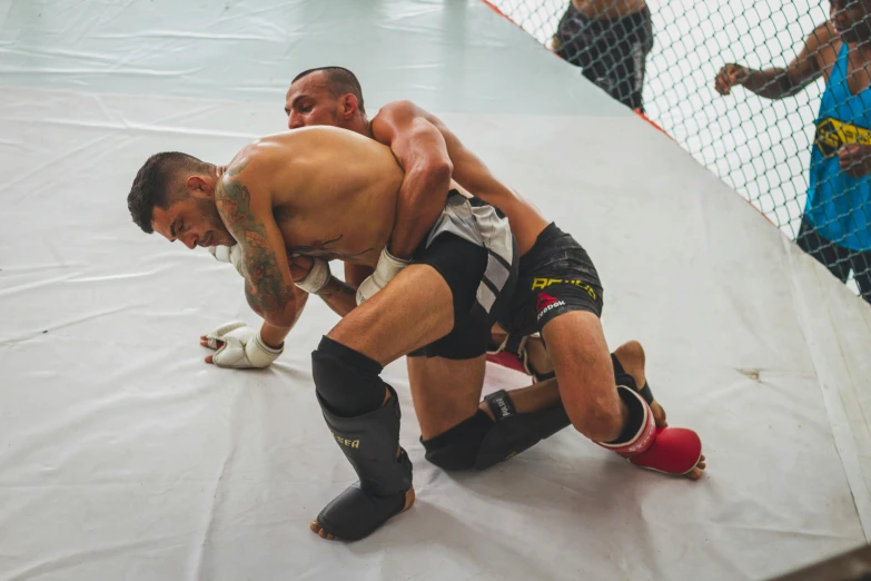 two men fighting at an open gym