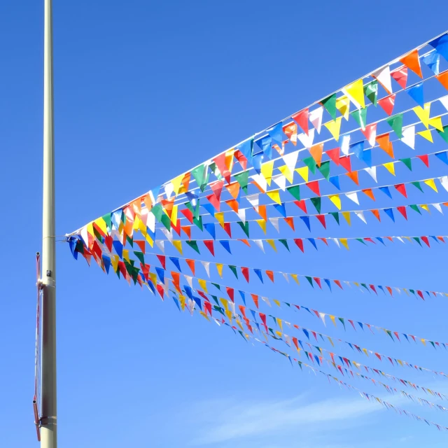 a row of colorful flags and street lights in the background