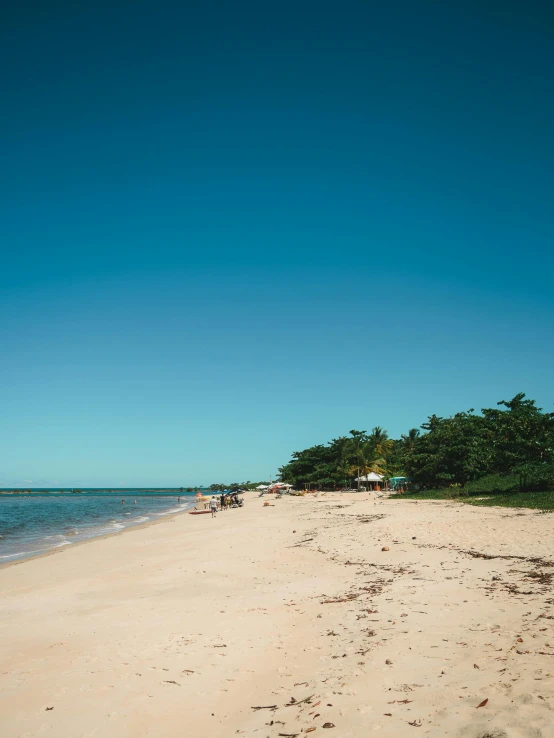 a sandy beach next to the ocean on a sunny day