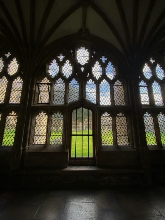 a building with large arched windows and a grass field behind it