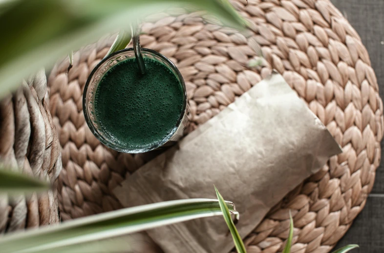 a jar on top of a round pillow next to some plants