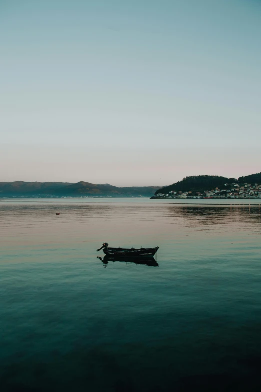 small boat floating on still water near shore