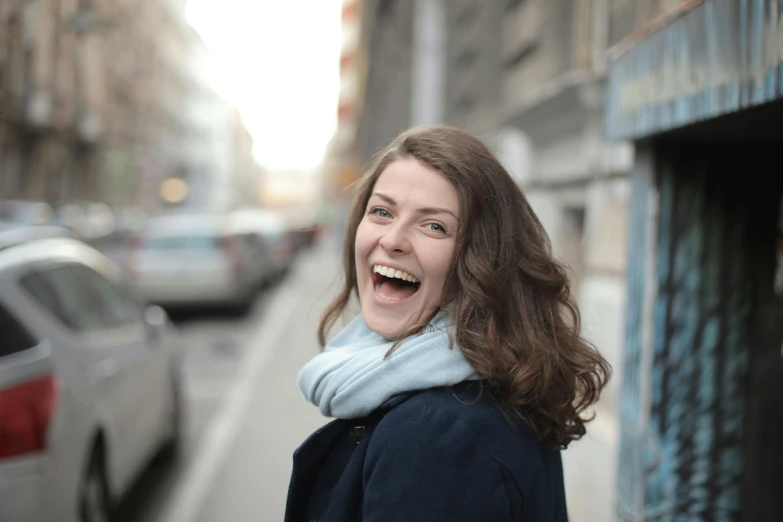 an attractive lady smiling for the camera near some buildings