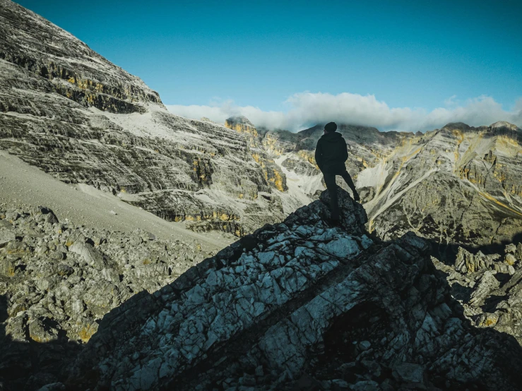 a person standing on a large rock in the mountains