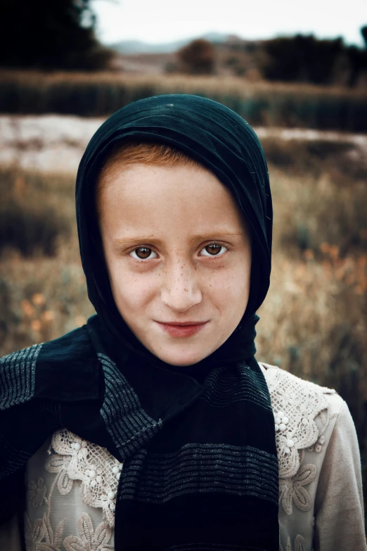 a  wearing a black scarf standing in an open field