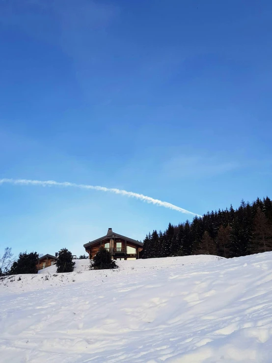 two airplanes flying in the sky over trees on a snowy hill