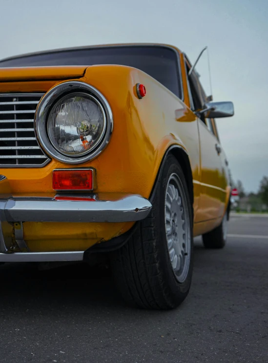 an old yellow car with some metal pipes