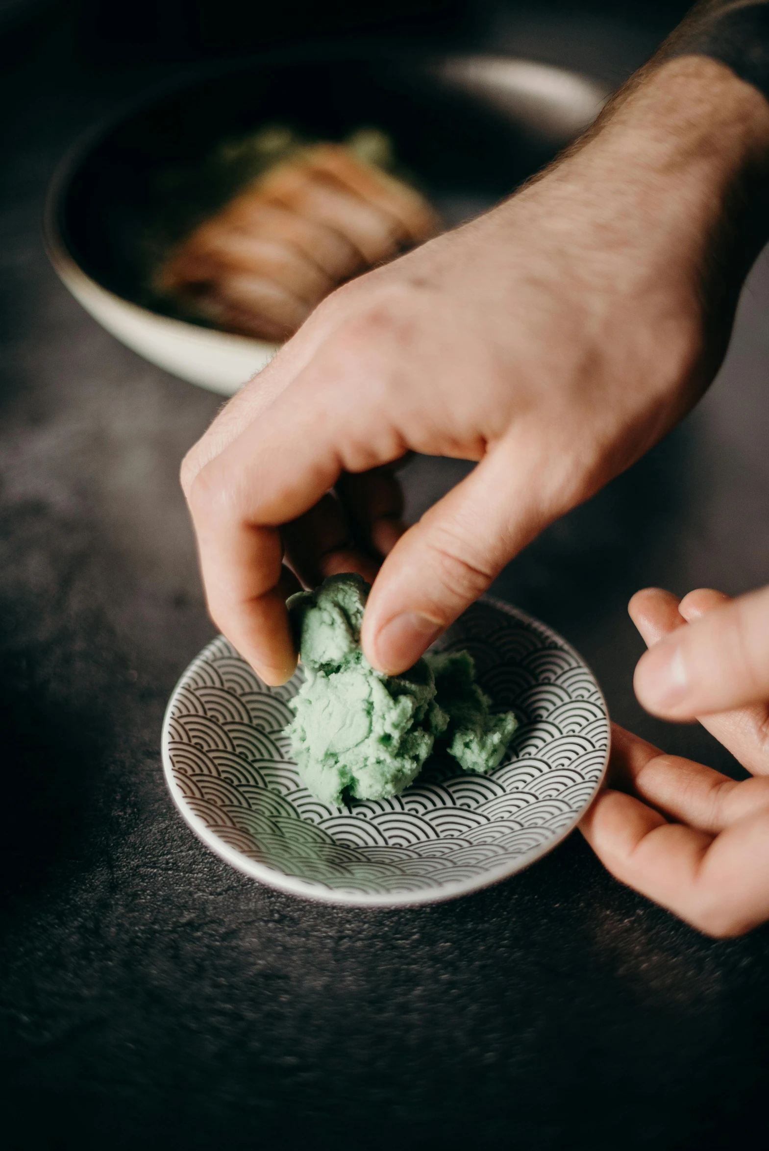 a person picking up soing from a small bowl