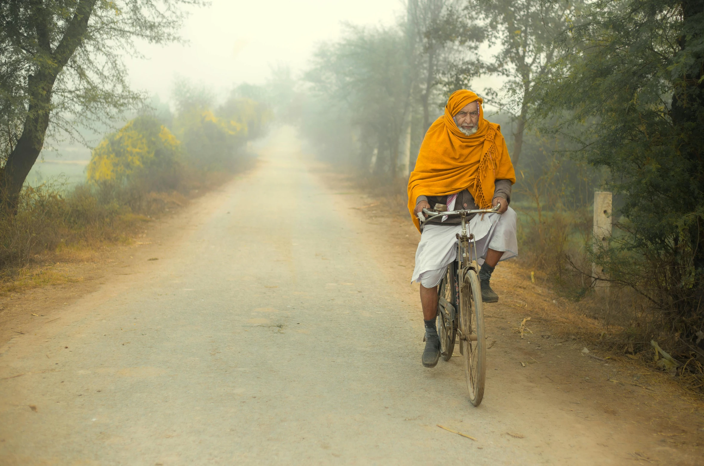 a person on a bicycle wearing a yellow scarf