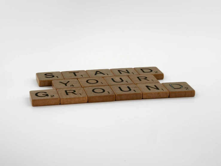 scrabbled word blocks spelling a word that says stand, you're ground