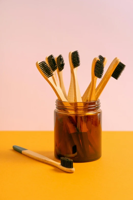 six toothbrushes that have just been placed in a jar