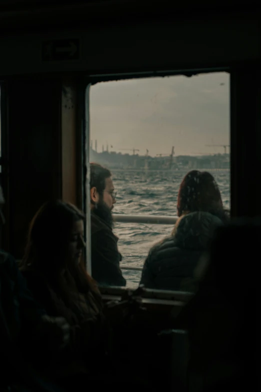 two people sitting inside a boat looking at a view of the ocean