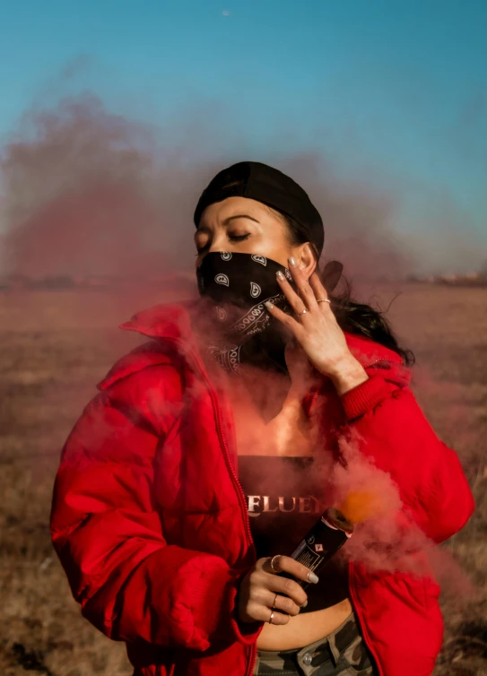 a woman stands outside with smoke and smoke behind her