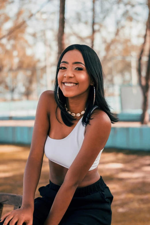 a woman wearing a white top posing for a po