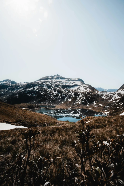 a mountain lake sitting on top of a snow covered hillside