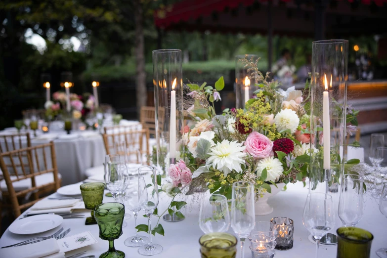 a table with white table cloth, flowers and candles