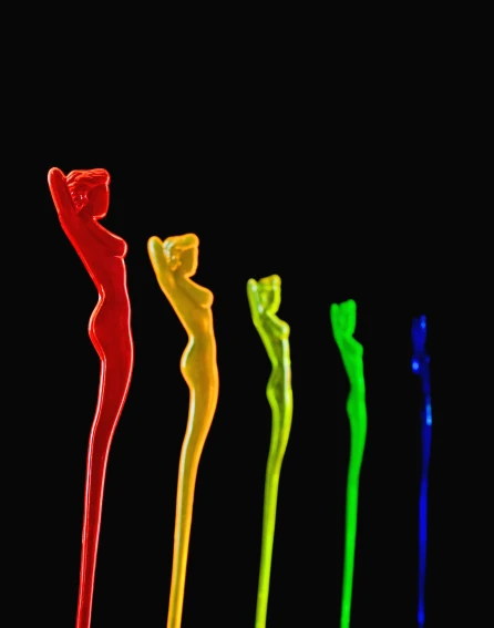 four toothbrushes are lit up by colored powder
