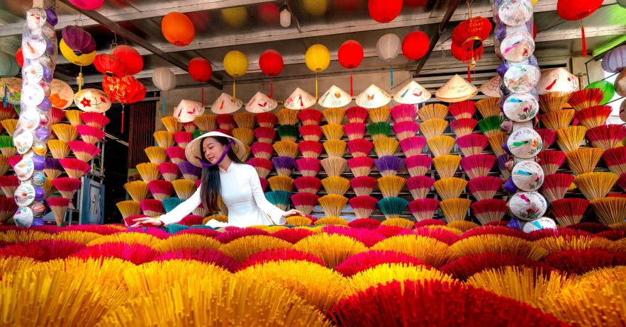 a woman in a shop displays a large array of paper lanterns