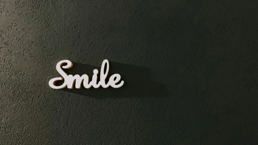 the word smile made of cut paper sits on a black surface
