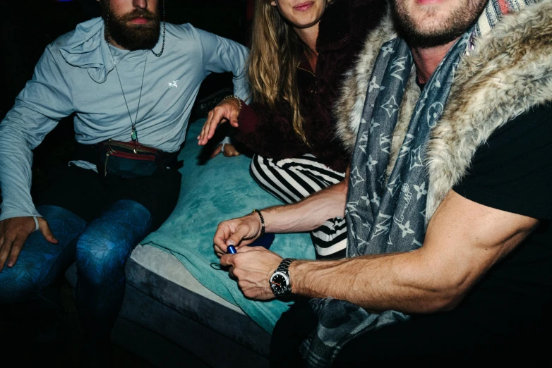 three people sitting on an odd shaped cushion