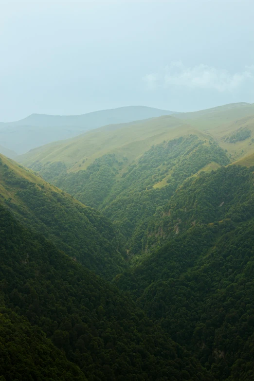 a very tall mountain that has some green hills on it