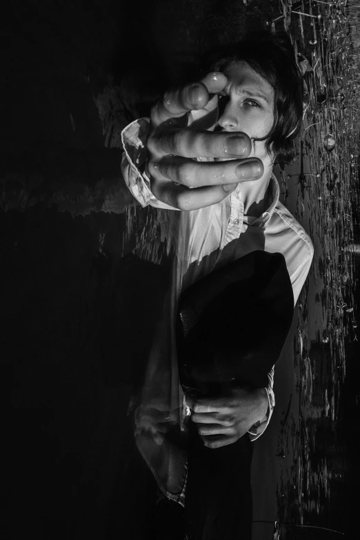 a man wearing suspenders while standing in front of a rain soaked wall