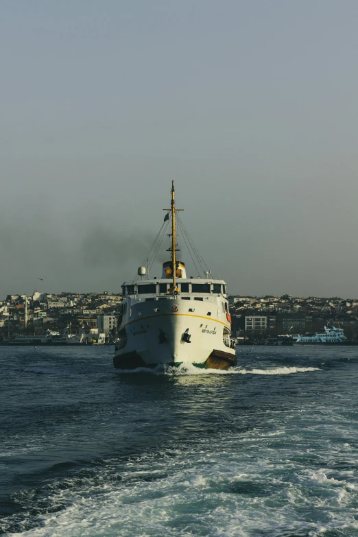 a small boat traveling in the ocean with a lot of buildings