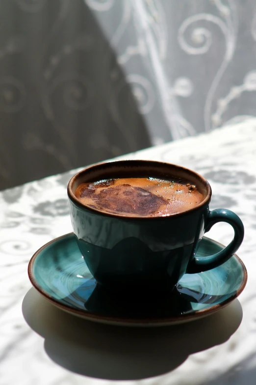 a blue and white cup is next to a saucer