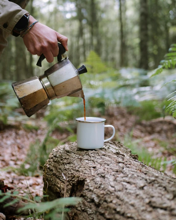 a coffee cup being filled with liquid from a pitcher