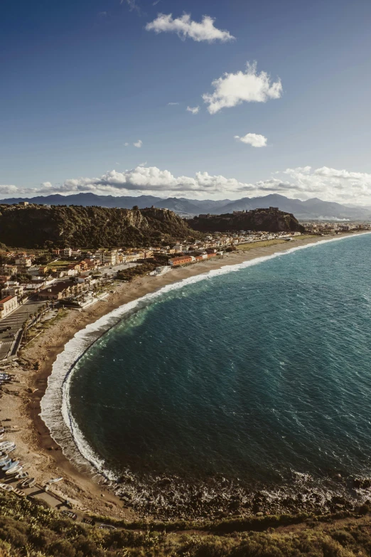 an aerial view of an ocean with the sandy shore