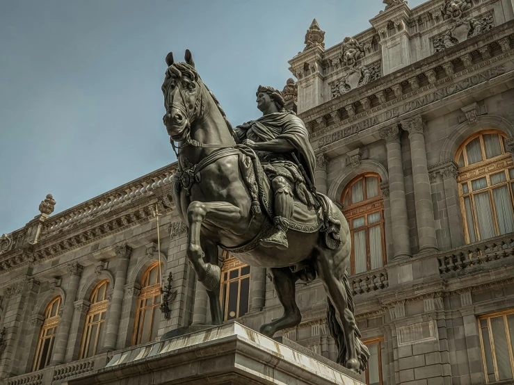 a man on a horse statue in front of a building