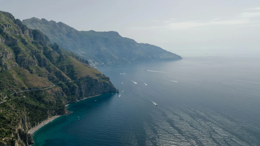 an aerial view of a boat cruising past the shore