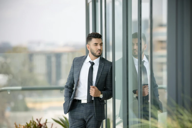 two men dressed in suits one is standing next to the other