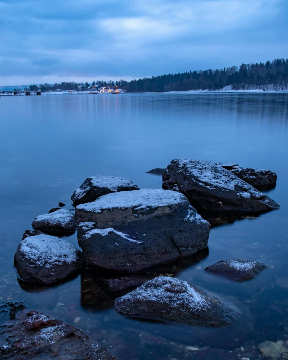 rocky shore on lake during winter with blue sky