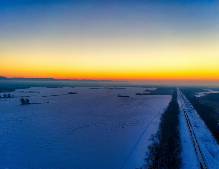 a train on snow covered ground with hills in the distance