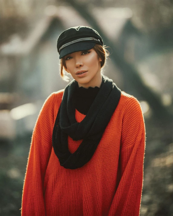 a person wearing an orange sweater and black beanie