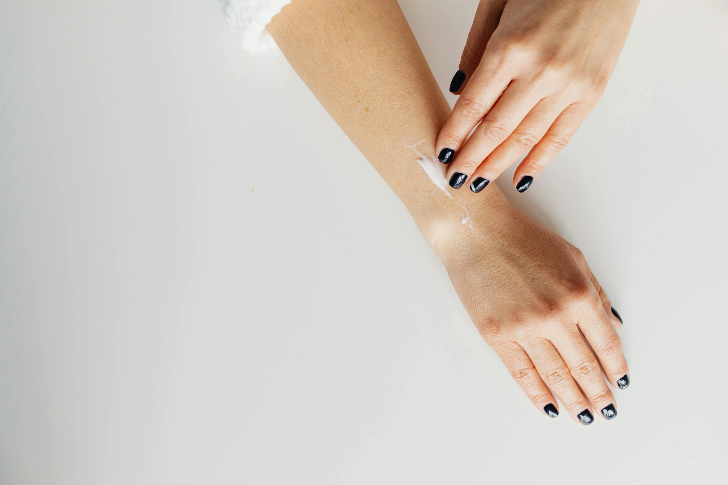 a woman's hands with french manies, a pair of black nail polish