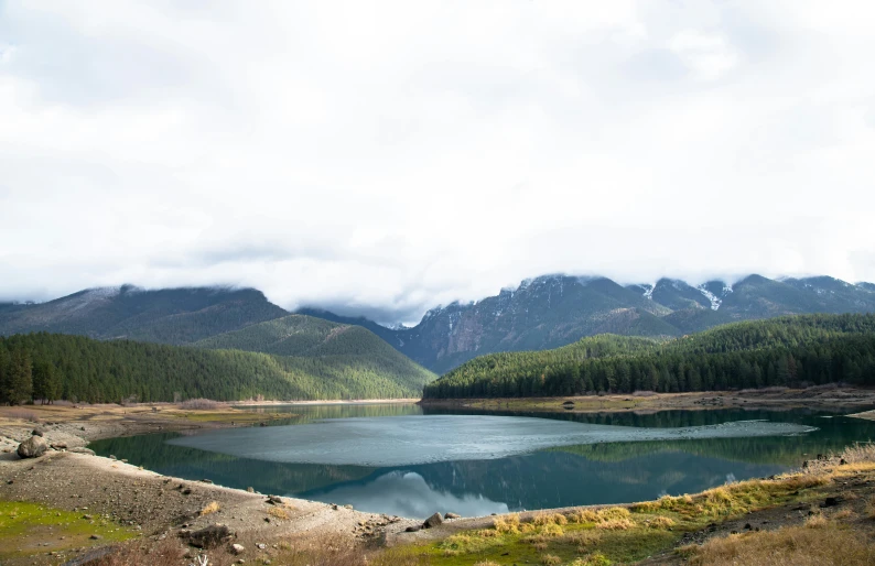 a green mountain lake in the middle of a mountain range