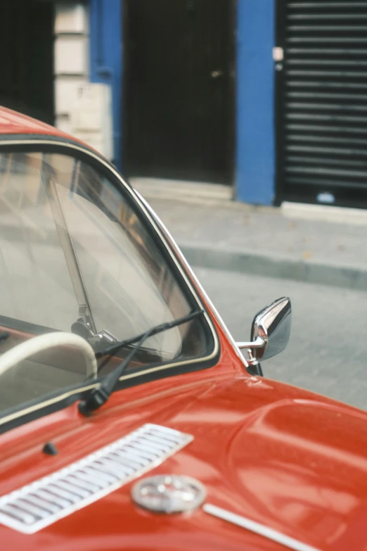 there is a red car that is parked near a street