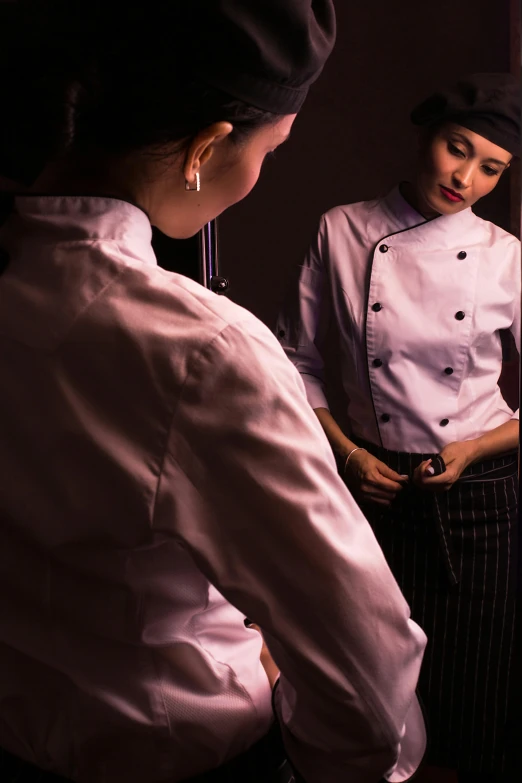 a young woman in uniform is looking into a mirror