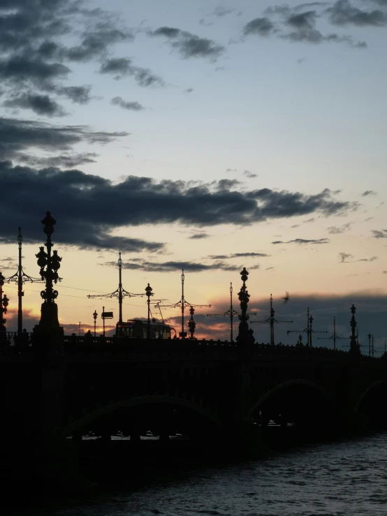 a bridge over the water next to an orange light