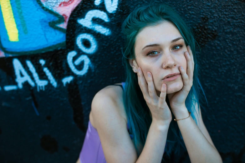 a woman standing with her hands in her face