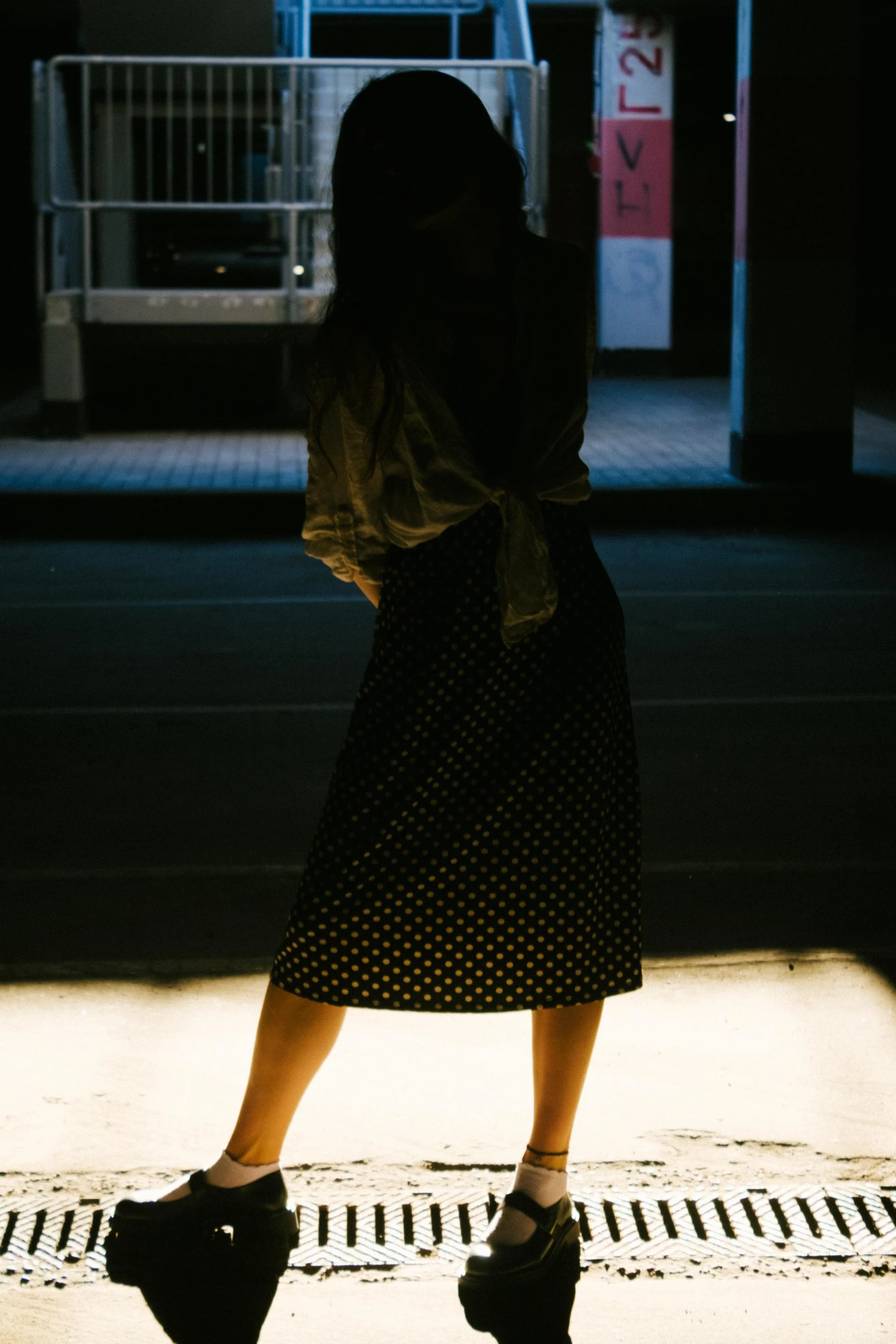 a person is wearing black shoes standing on the sidewalk