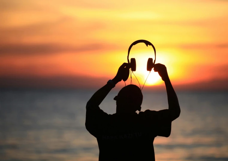 a person is holding two headphones in their hands