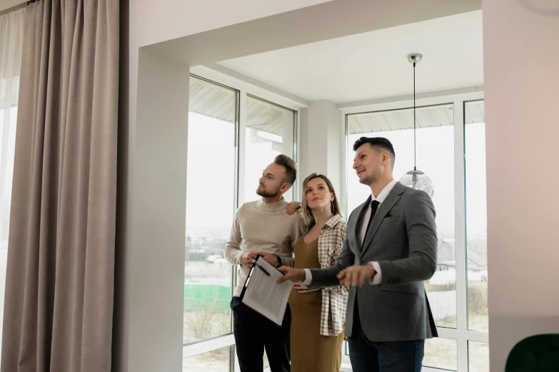 three people and one woman looking out of an apartment window