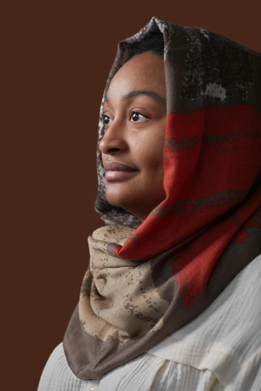 a person with a scarf on a brown background