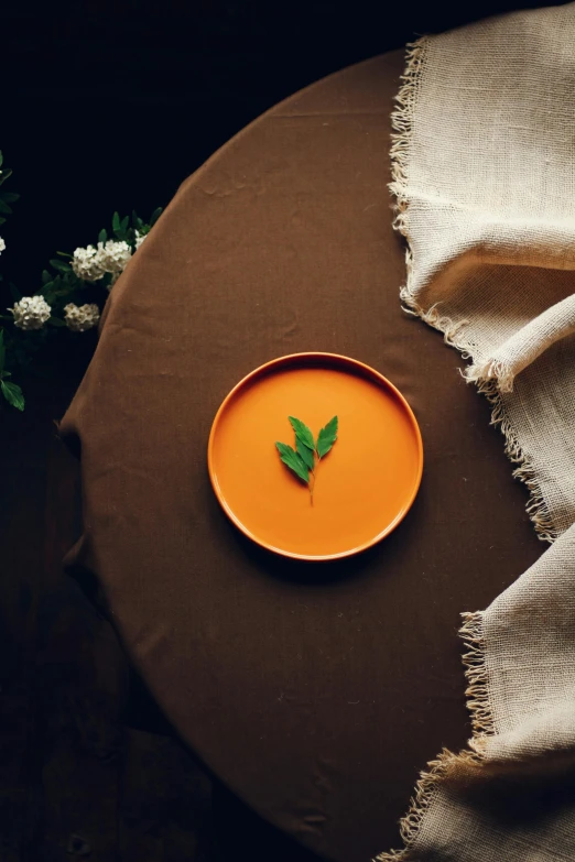 a small plate with a leaf on top of it