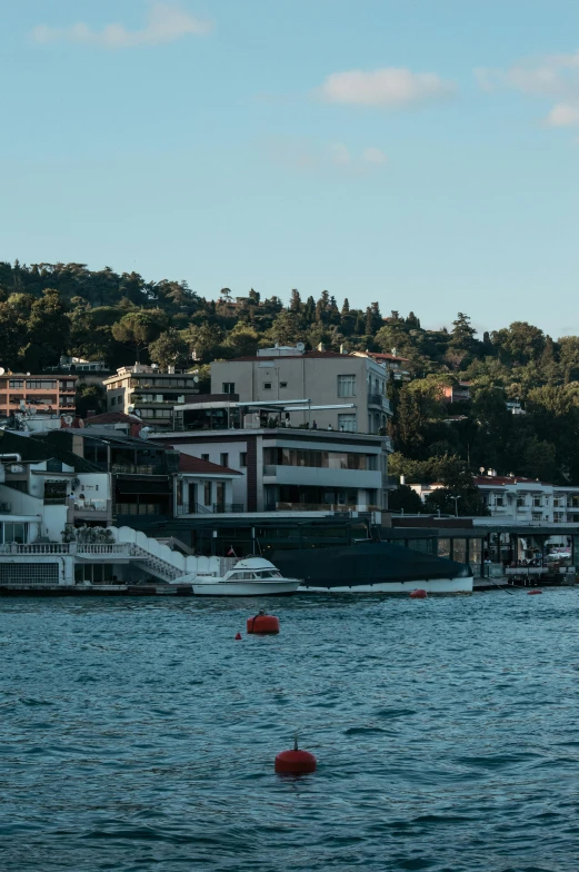 boats are moored in a bay with houses on the hill side