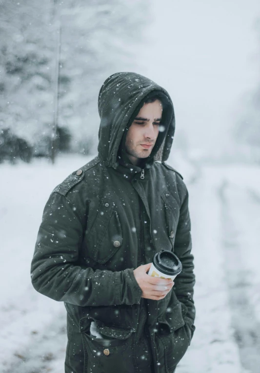 man with cold drink standing in the snow